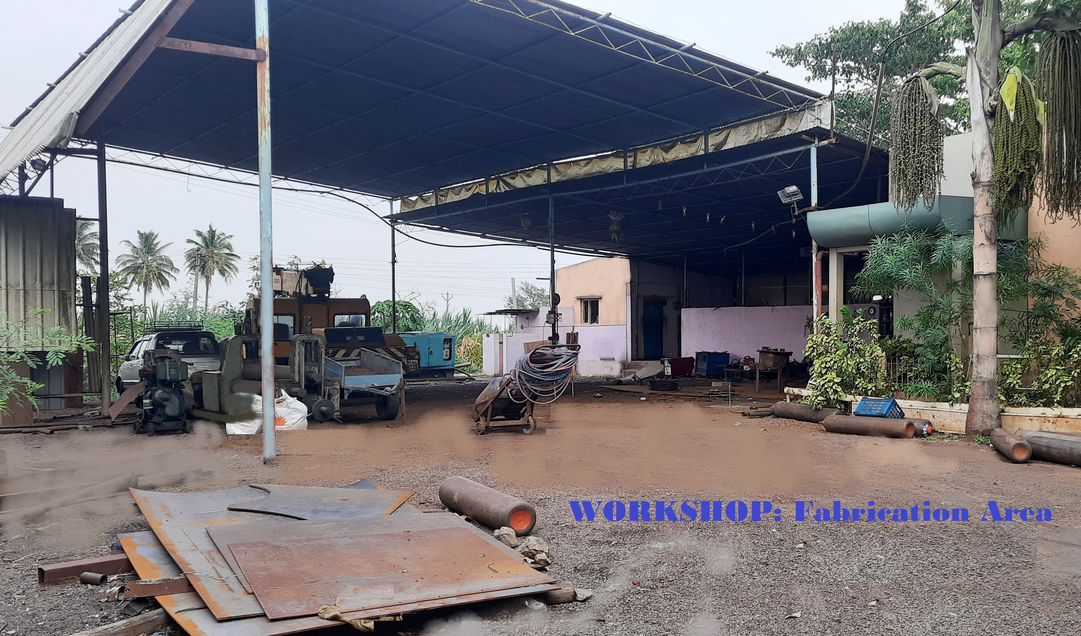 Rajhans Industries workshop and fabrication yard, Baramati — steel plates, pipes, and welding equipment on the shop floor