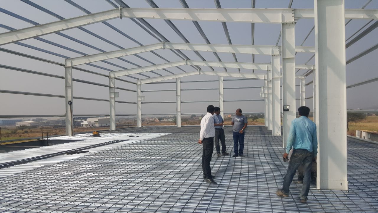 Curved arch portal frame PEB warehouse under construction — Rajhans Industries