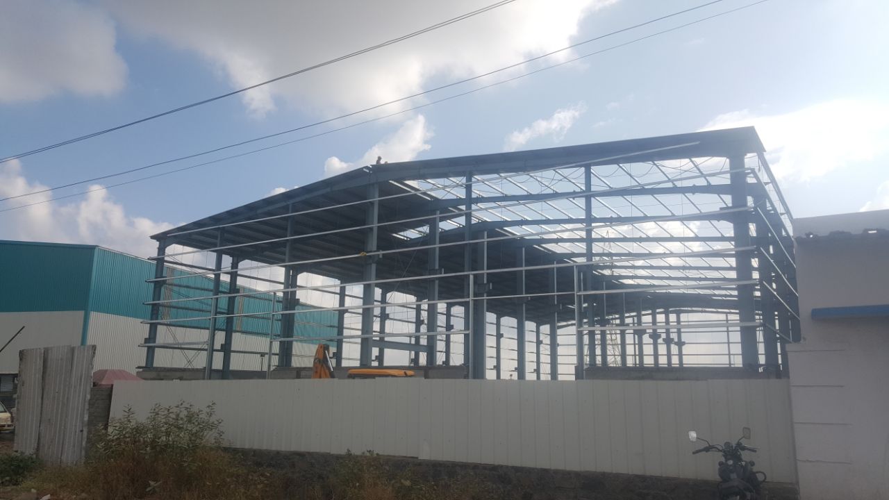 Large span warehouse interior with site team — Rajhans Industries